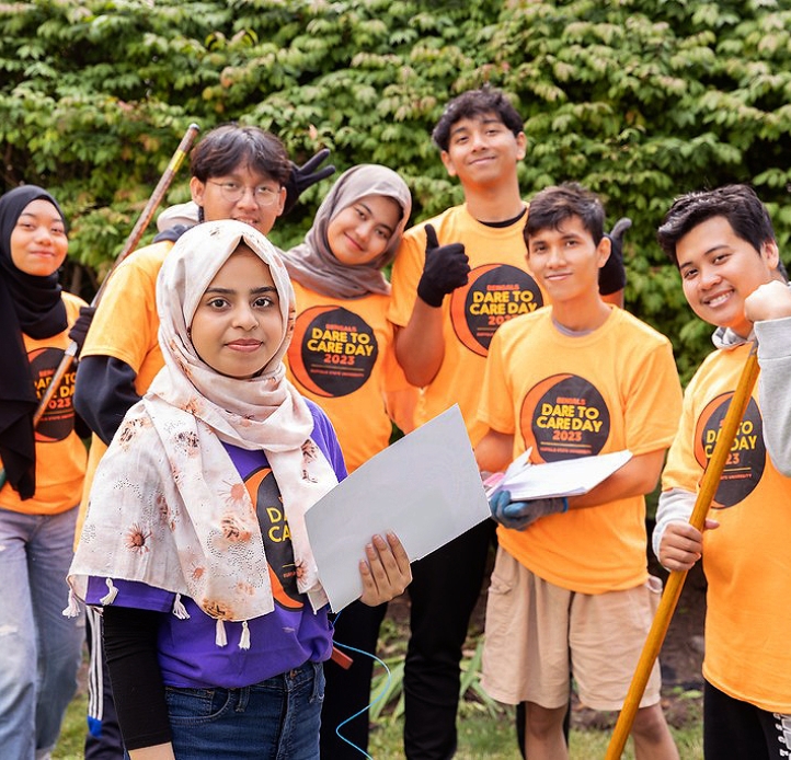 Group of students outside with rakes