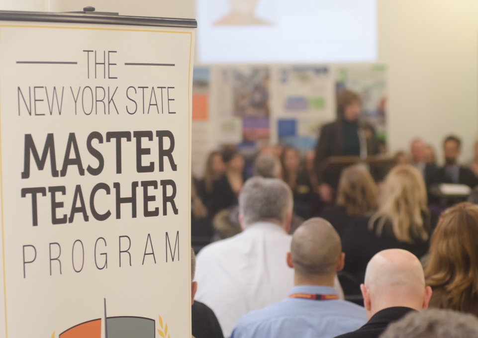 A sign that reads The New York State Master Teacher Program next to a group of people
